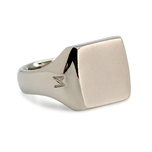 Single silver-colored titanium signet ring, 15x15 mm wide surface. Image shows corner view of the ring
