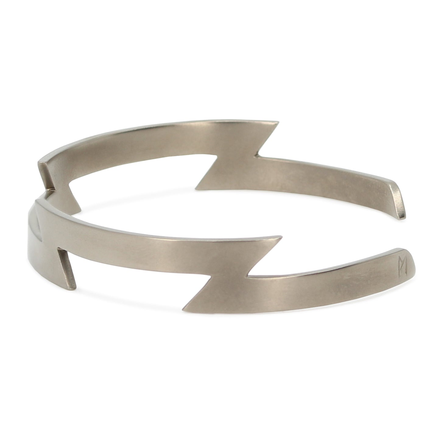 Side view of Maxwell Pontail's angular titanium bracelet with subtle 'M' engraving.
