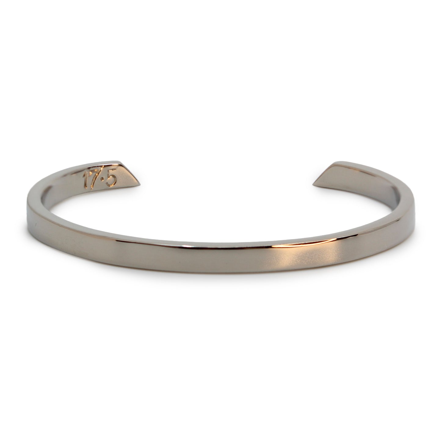 Close-up view of a polished silver bracelet with a minimalist design, featuring an engraved '17.5' on one end.