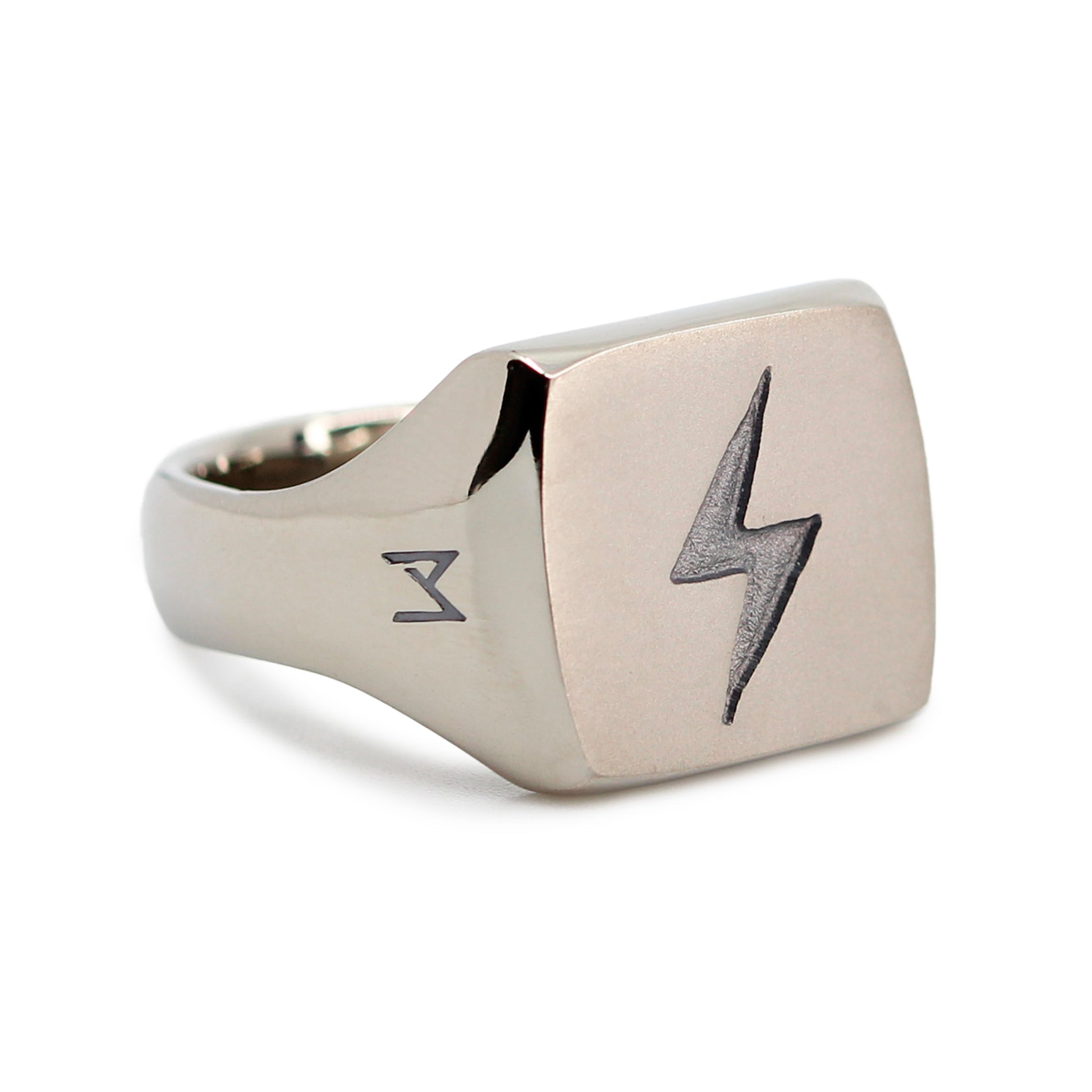 Single silver-colored titanium signet ring, 15x15 mm wide surface with an engraved lightning bolt. Image shows corner view of the ring