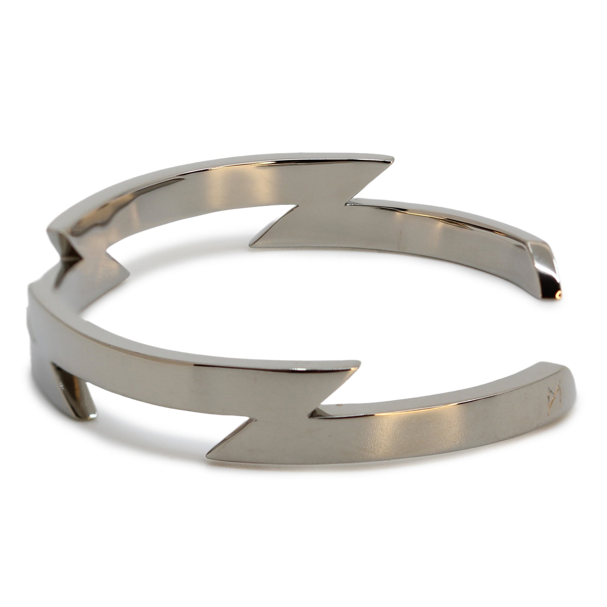 Single silver-colored titanium bangle with zig-zag pattern, 1 cm thick. Image shows side view of bangle.