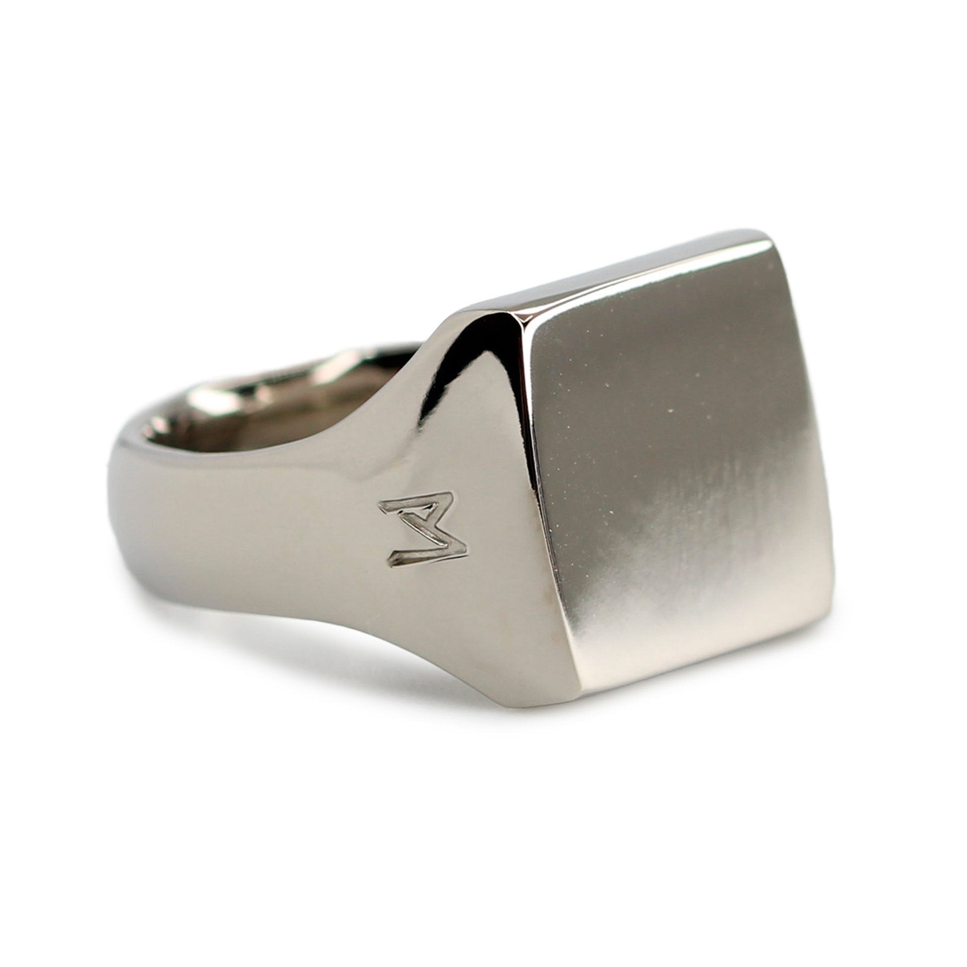 Single silver-colored titanium signet ring, 15x15 mm wide surface. Image shows corner view of the ring